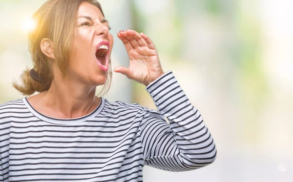 中年资深西班牙裔妇女在孤立的背景下大声喊叫 并与手在嘴上尖叫 沟通理念 — 图库照片