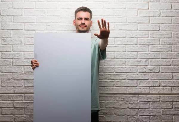 Ung Vuxen Man Över Tegelvägg Holding Banner Med Öppna Hand — Stockfoto