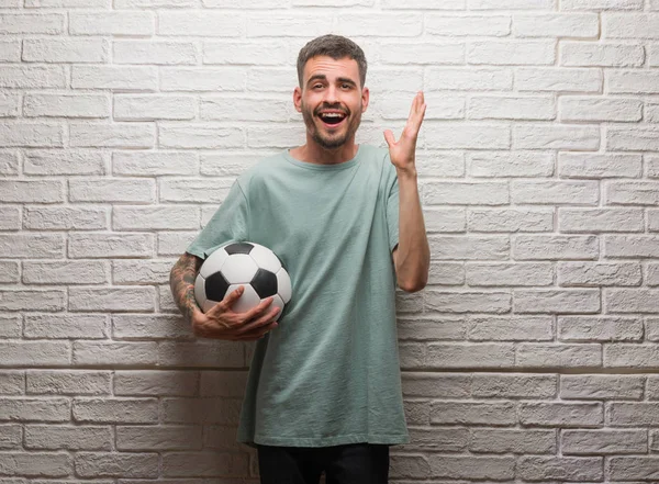 Homem Adulto Jovem Segurando Bola Futebol Sobre Parede Tijolo Branco — Fotografia de Stock