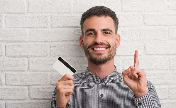 Junger Erwachsener Mann Über Ziegelmauer Mit Kreditkarte Überrascht Mit Einer — Stockfoto