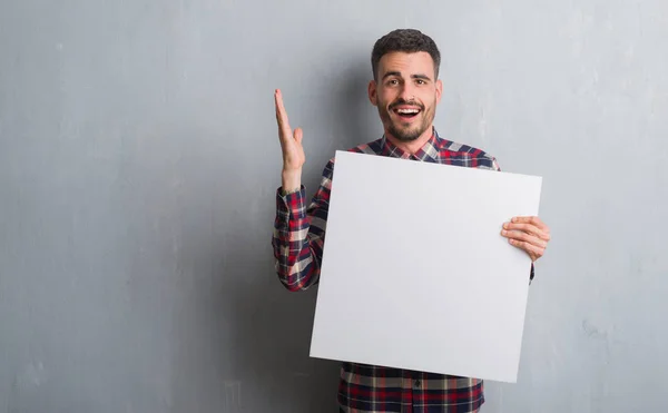 Hombre Adulto Joven Sobre Pared Ladrillo Sosteniendo Pancarta Muy Feliz —  Fotos de Stock