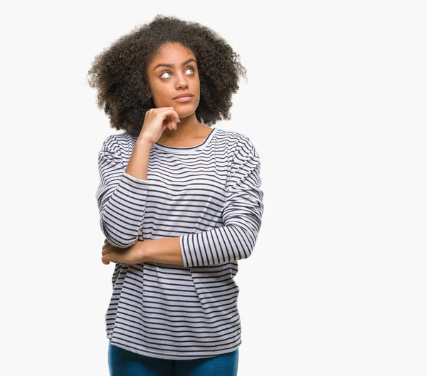 Çene düşünme hakkında soru, dalgın ifade üzerine el ile izole arka plan üzerinde genç afro Amerikalı kadın. Düşünceli yüzüyle gülümsüyor. Şüphe kavramı.