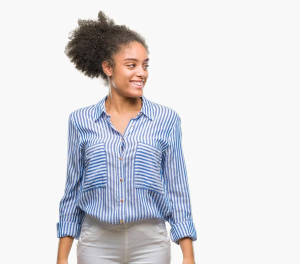 Uzak tarafına yüzünde, doğal ifade gülümseme ile seyir izole arka plan üzerinde genç afro Amerikalı kadın. Kendine güvenen gülüyor.