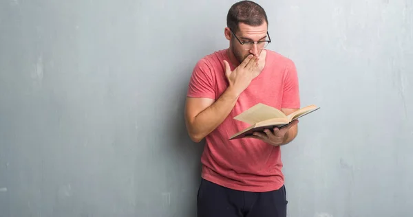 Young Caucasian Man Grey Grunge Wall Reading Book Cover Mouth — Stock Photo, Image