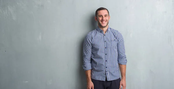 Joven Hombre Caucásico Sobre Pared Gris Grunge Con Una Sonrisa —  Fotos de Stock