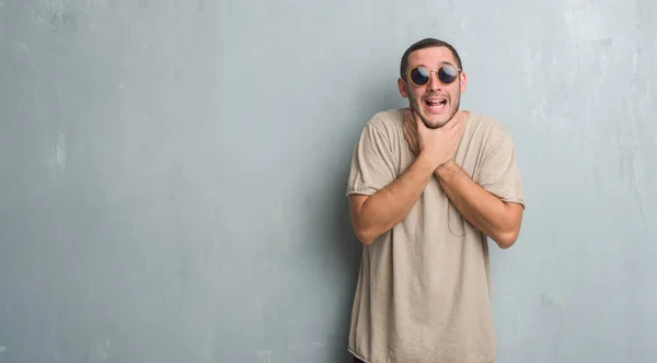 Genç Beyaz Adam Gri Grunge Duvardan Bağırarak Güneş Gözlüğü Takıyor — Stok fotoğraf