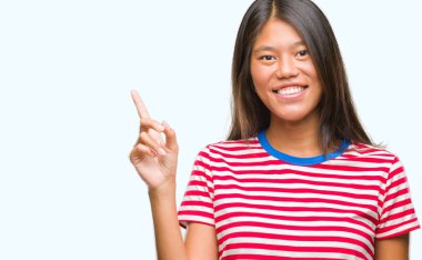 Kameraya bakarak yan el ve parmak ile işaret eden Genç Asyalı kadın yüzünde kocaman bir gülümseme ile izole arka plan üzerinde.