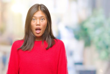 Korkuyor ve şok sürpriz ifade, korku ve heyecan yüz ile izole arka plan üzerinde kış kazak giyen genç Asyalı kadın.