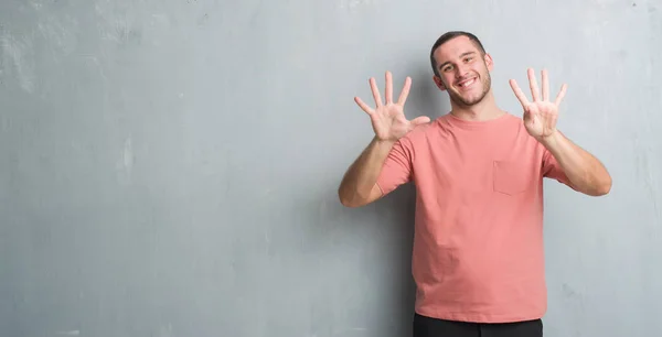 Joven Caucásico Hombre Sobre Gris Grunge Pared Mostrando Apuntando Hacia —  Fotos de Stock