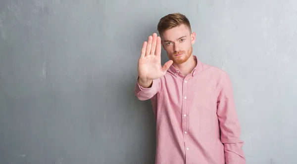 Człowiek Młody Rude Szary Mur Sobie Różową Koszulę Robi Stop — Zdjęcie stockowe