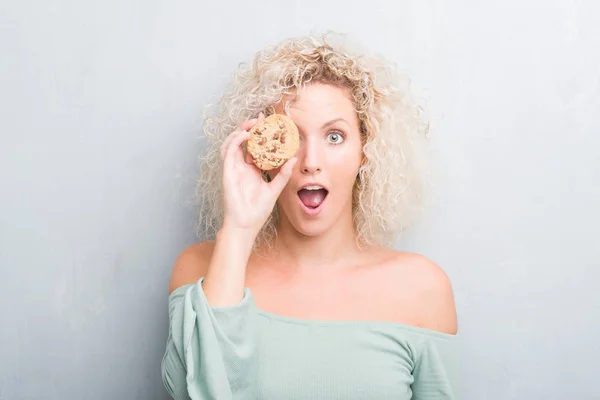 Jovem Loira Sobre Grunge Parede Cinza Comendo Panela Chocolate Frito — Fotografia de Stock