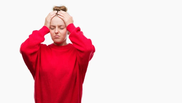 パンと赤いセーターのため絶望的なと強調した頭痛に苦しんで身に着けている若いブロンドの女性の痛みと片頭痛 頭に手 — ストック写真