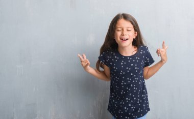 Genç İspanyol çocuk deli ifade rock simge elle yapıyor ile bağırarak grunge gri duvar için. Müzik yıldızı. Ağır kavramı.