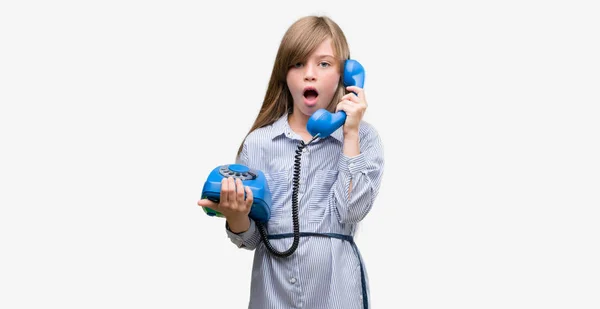 年轻的金发学步的孩子拿着老式电话吓坏了惊讶的脸 害怕和兴奋与恐惧的表情 — 图库照片
