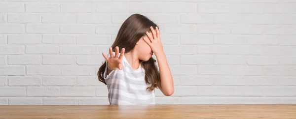 Jonge Spaanse Kid Zittend Tafel Thuis Bedekking Ogen Met Handen — Stockfoto