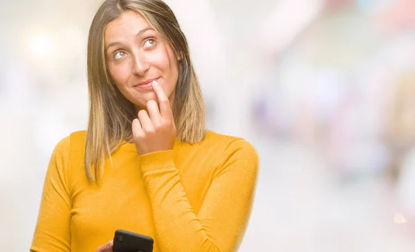 年轻美丽的女人发送消息使用智能手机在孤立的背景下严肃的面孔思考问题 非常困惑的想法 — 图库照片