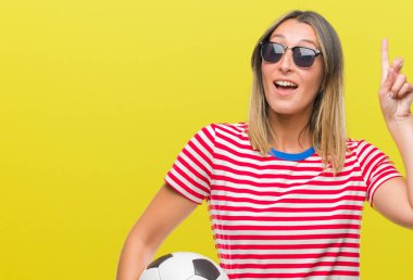 Futbol futbol topu izole arka plan üzerinde bir fikir ya da soru işaret parmağı gülen yüz, bir numara ile sürpriz tutan genç güzel kadın