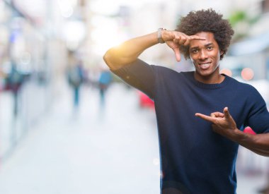 Elle yapma çerçeve ve parmakları ile mutlu yüz gülümseyen izole arka plan üzerinde Afro Amerikalı adam. Yaratıcılık ve Fotoğrafçılık kavramı.