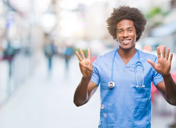 Afro american surgeon doctor man over isolated background showing and pointing up with fingers number eight while smiling confident and happy.
