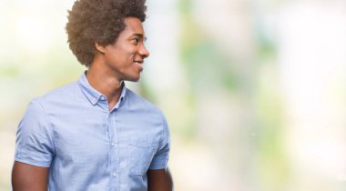 Uzak tarafına yüzünde, doğal ifade gülümseme ile seyir izole arka plan üzerinde Afro Amerikalı adam. Kendine güvenen gülüyor.