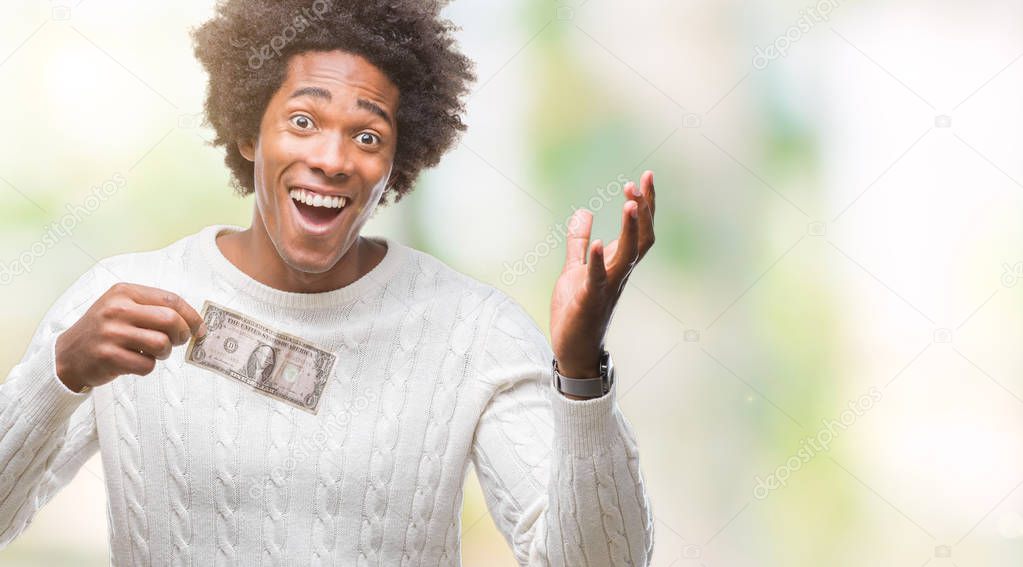 Afro american man holding one dollar over isolated background very happy and excited, winner expression celebrating victory screaming with big smile and raised hands