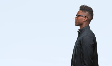 İzole arka tarafına, arayan genç Afro-Amerikan rahip adam sakin ol kendine güvenen gülümseme ile doğal yüz pozuyla profili.