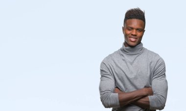 İzole arka plan mutlu yüz çapraz silah kameraya bakarak ile gülümseyen genç Afro-Amerikan adam. Olumlu bir kişi.