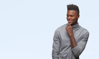 Afrikalı-Amerikalı genç emin çapraz kollar ve çeneme kaldırdı el ile gülümseme ile kameraya bakarak izole arka plan üzerinde. Pozitif düşünce.