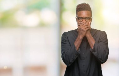 İzole arka plan ağız hata için elleriyle kapsayan şok genç Afro-Amerikan rahip adam. Gizli kavramı.