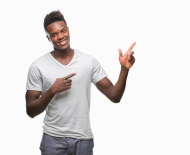 Gülümseyen ve iki elleri ve parmakları ile tarafına işaret kamera bakarak izole arka plan üzerinde genç Afro-Amerikan adam.