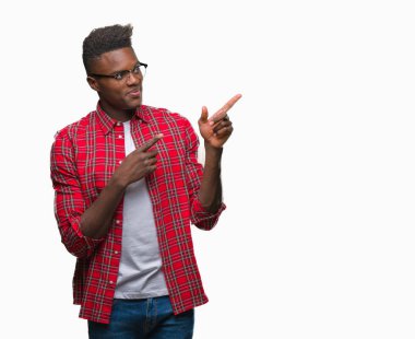 Gülümseyen ve iki elleri ve parmakları ile tarafına işaret kamera bakarak izole arka plan üzerinde genç Afro-Amerikan adam.