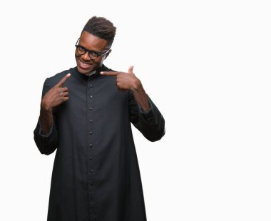 Genç Afro-Amerikan rahip adam kendinden emin gösterilen ve işaret parmakları diş ve ağız ile gülümseyen izole arka plan üzerinde. Sağlık kavramı.