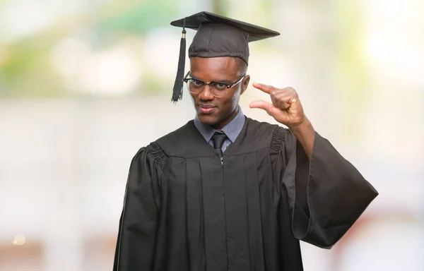 Young graduated african american man over isolated background smiling and confident gesturing with hand doing size sign with fingers while looking and the camera. Measure concept.