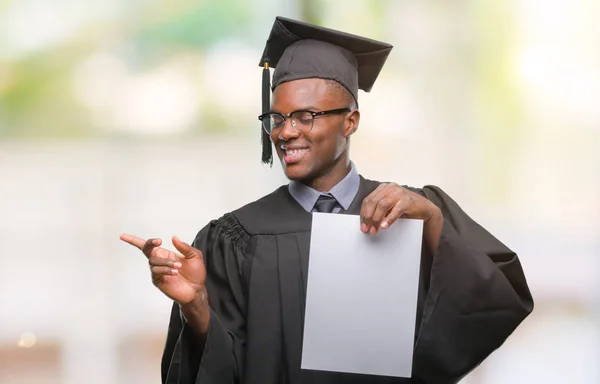 ヤング卒業側の手と指で指す非常に幸せな孤立した背景に白紙の学位を保持するアフリカ系アメリカ人 — ストック写真