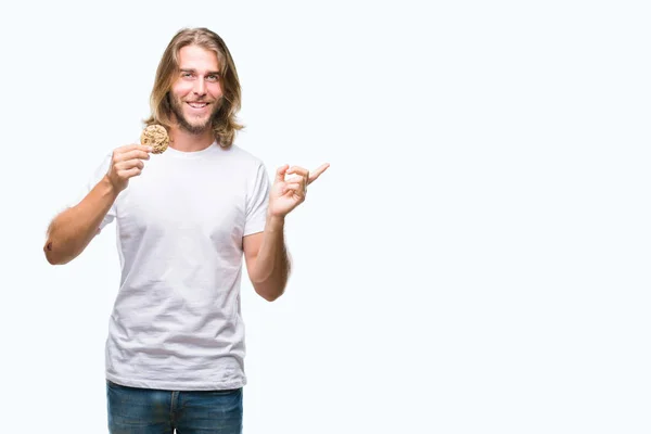 Jonge Knappe Man Met Lange Haren Eten Chocolade Cookie Geïsoleerde — Stockfoto