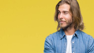 Görünümlü yan ve dik dik bakma uzağa düşünce gülümseyen izole arka plan üzerinde uzun saçlı yakışıklı delikanlı.