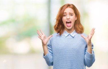 Genç güzel kadın çılgın kutlama kış kazak giyen ve silah ile başarı için heyecanlı çığlık kaldırdı ve açık gözleri hayret izole arka plan yüzünden. Kazanan kavramı