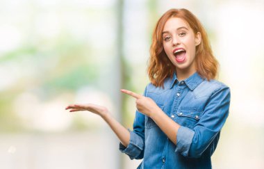 Genç güzel kadın üzerinden hayran ve el ile sunulması ve parmak ile işaret ederken kameraya gülümseyen izole arka plan.