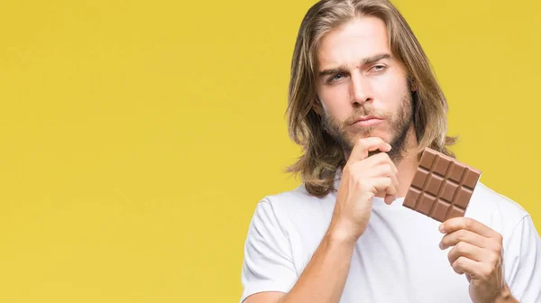 Jovem Homem Bonito Com Cabelos Longos Comendo Barra Chocolate Sobre — Fotografia de Stock