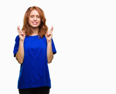 Umut ve gözleri kapalı geçiş parmaklarıyla gülümseyen izole arka plan üzerinde genç güzel kadın. Şans ve batıl kavramı.