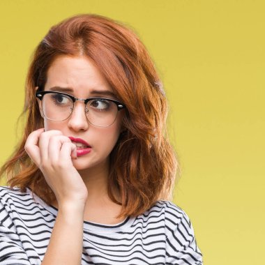 İzole arka plan stresli ve gergin ile eller tırnak ısırma dudaklarından seyir gözlüklü genç güzel kadın. Anksiyete sorunu.