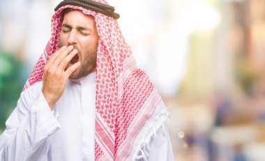 Keffiyeh izole arka plan üzerinde giyen genç yakışıklı adam el ağzıyla kapsayan yorgun esneme sıkılmış. Restless ve uyku hali.