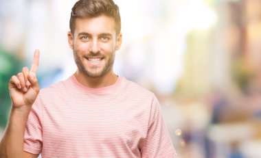 Yakışıklı delikanlı gösterilen ve kendinden emin ve mutlu gülümseyen bir parmak ile işaret eden oktan yukarı izole arka plan üzerinde.