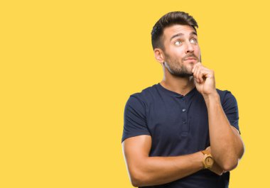 Yakışıklı delikanlı çene düşünme hakkında soru, dalgın ifade üzerine el ile izole arka plan üzerinde. Düşünceli yüzüyle gülümsüyor. Şüphe kavramı.