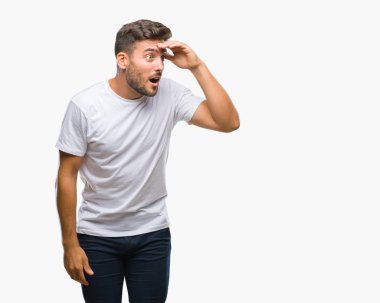 Yakışıklı delikanlı izole arka plan çok mutlu ve gülümseyen uzakta el ile üzerine kafa seyir üzerinde. Arama kavramı.