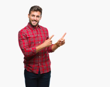 Yakışıklı delikanlı gülümseyen ve iki elleri ve parmakları ile tarafına işaret kamera bakarak izole arka plan üzerinde.