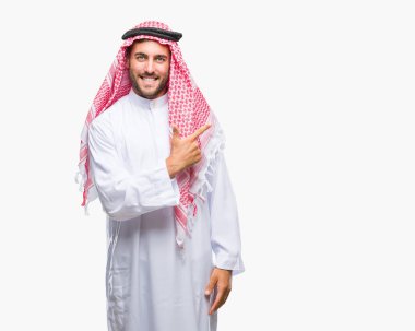 Keffiyeh izole arka neşeli bir gülümseme ile el ve parmak kadar kameraya bakarak yüzündeki mutlu ve doğal ifade ile yan ile işaret yüz üzerinde giyen genç yakışıklı adam.