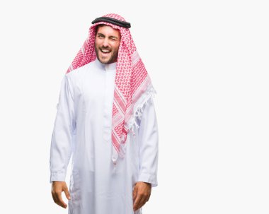Seksi bir ifadeyle, neşeli ve mutlu yüzünü kameraya bakarak göz kırpıyor izole arka plan üzerinde keffiyeh giyen genç yakışıklı adam.
