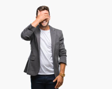 Genç yakışıklı iş adamı gülümsüyor ve gözleri için sürpriz kapsayan yüz el ile gülüyor izole arka plan üzerinde. Kör kavramı.