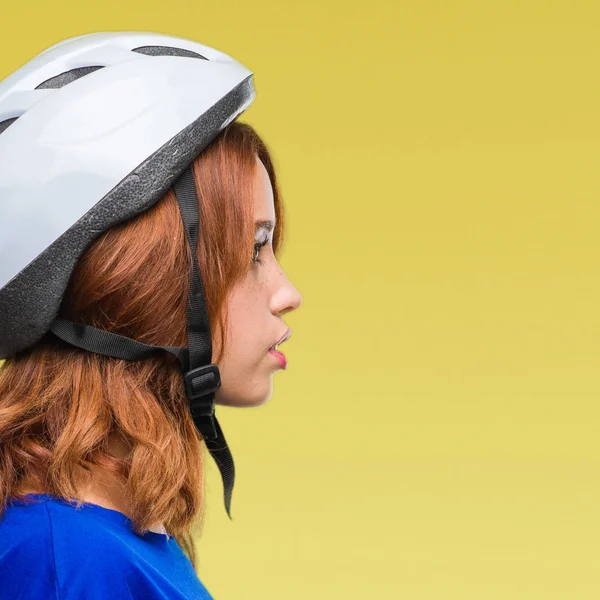 年轻漂亮的女人穿着自行车头盔在孤立的背景看着侧面 放松轮廓与自然的脸上充满自信的微笑的姿态 — 图库照片